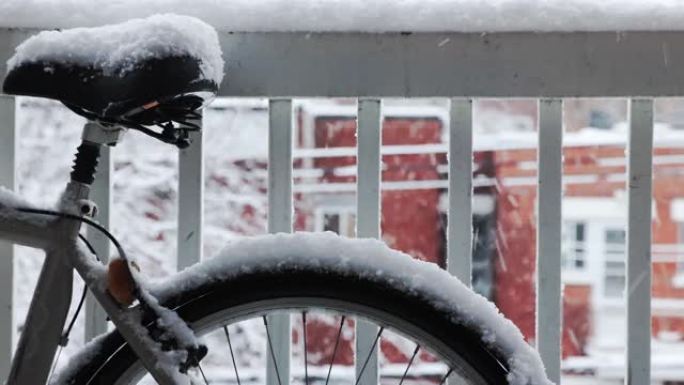 暴风雨中自行车的车轮和鞍座被雪覆盖的特写镜头