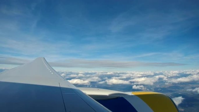 透过飞机的窗户，从天上透过云层，从天上看云层和大地。航拍镜头。旅游概念。