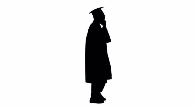 剪影微笑着穿着毕业长袍的非洲裔美国男学生边走边打电话