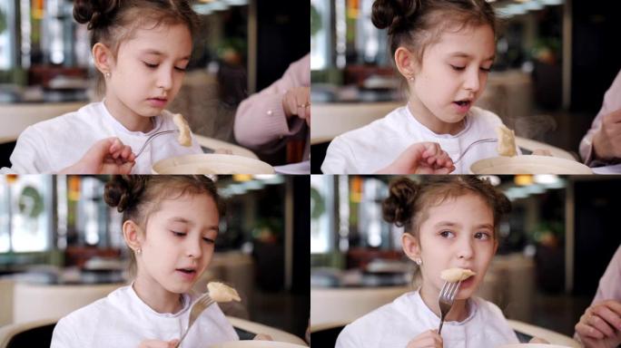 小女孩在咖啡馆吃热腾腾的饺子。