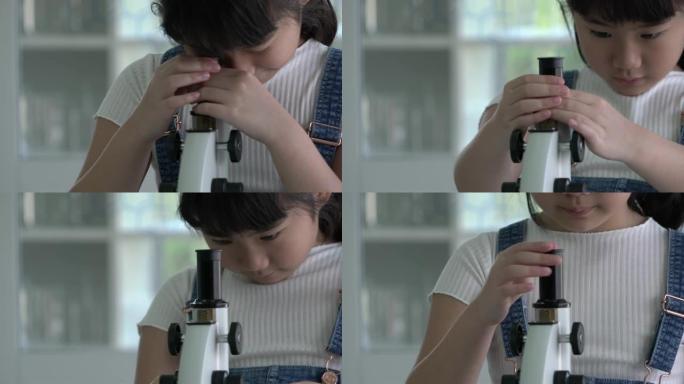 小女孩正在学校的现代实验室里通过显微镜观察。科学、学习发展和实验室产业的概念。