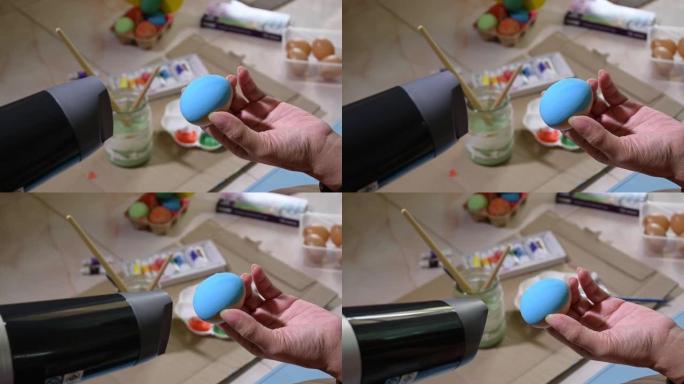 人们用烘干机吹复活节彩蛋工艺品干颜色