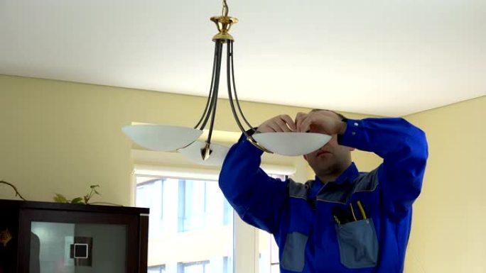 经验丰富的电工在客户家里换灯泡。