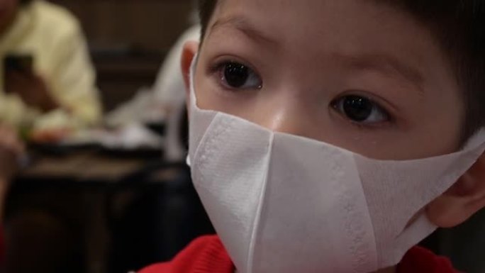 亚洲孩子戴着卫生口罩保护自己免受大流行病毒和空气粉尘污染