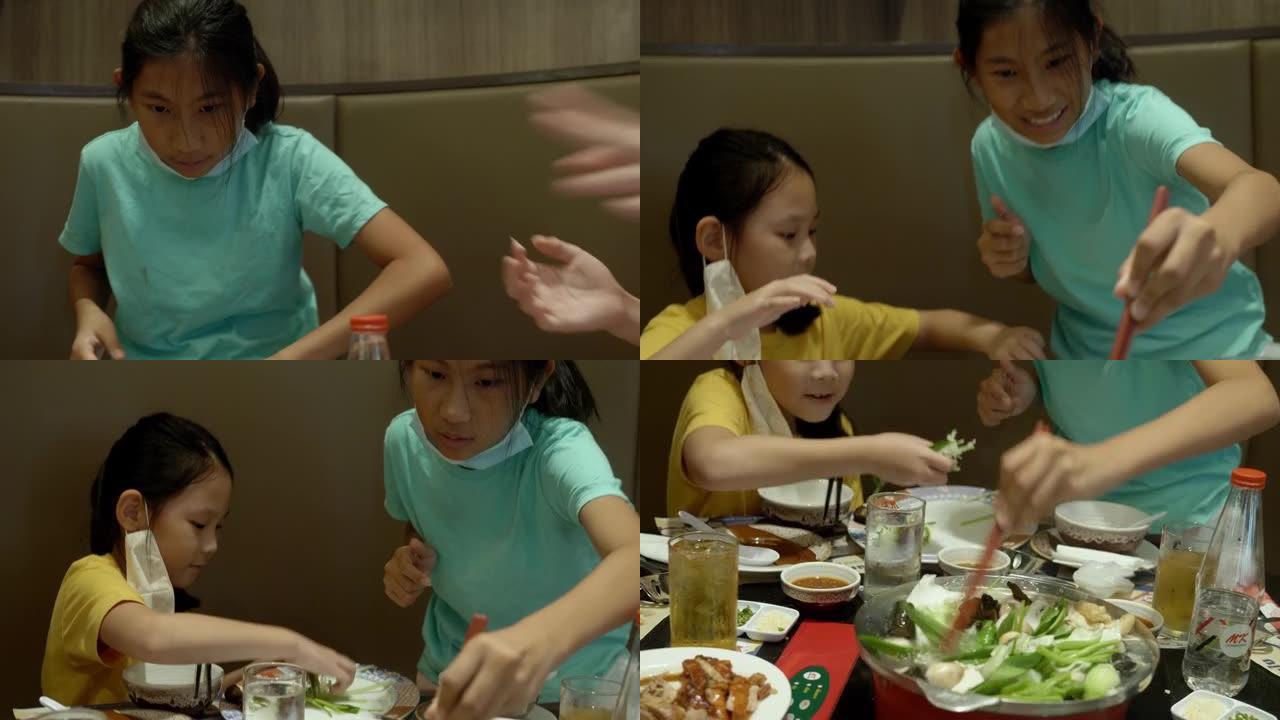 快乐的3个亚洲女孩在餐厅和家人一起吃寿喜烧、烧锅或火锅，生活方式理念。