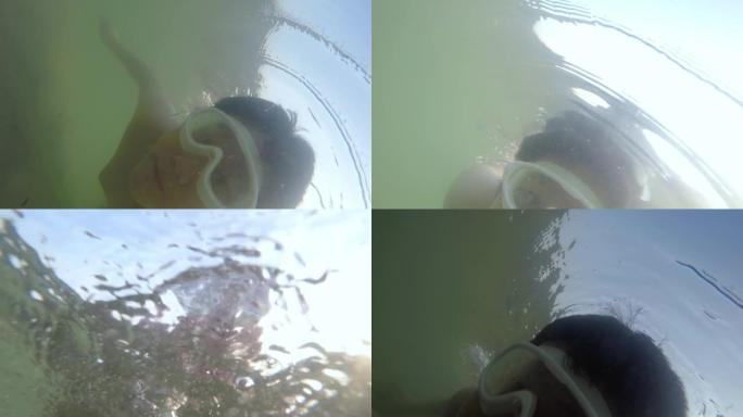 快乐的亚洲男孩在海底潜水，看着相机，生活方式的概念。