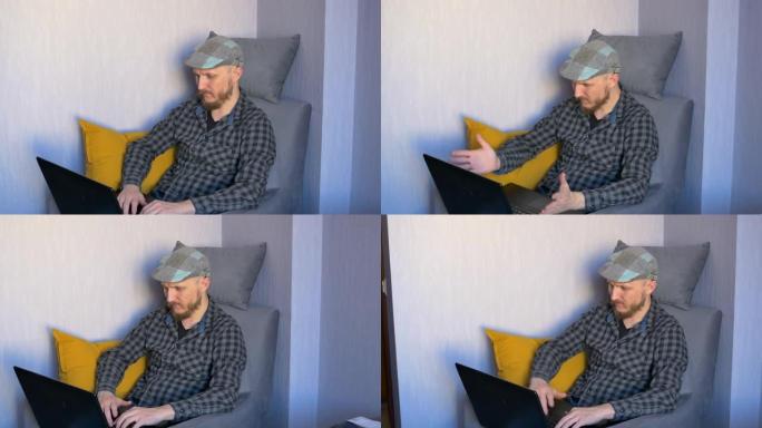 一个戴着帽子的男人坐在椅子上，情绪激动地在笔记本电脑上打字，关上盖子