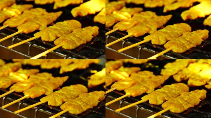 食品视频沙爹猪肉或鸡肉用竹子制成，然后在柴炉或木炭烤箱上烧烤，街头食品沙爹的调味料来自印度尼西亚的爪