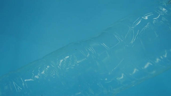 塑料水瓶漂浮在水中，而男人的手却在捡起，塑料意识，水中的塑料污染概念。