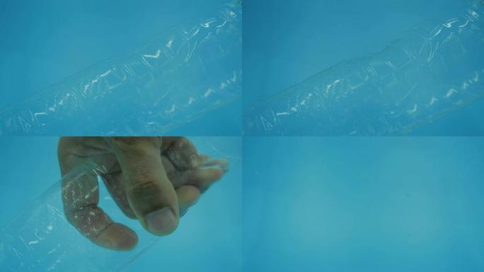 塑料水瓶漂浮在水中，而男人的手却在捡起，塑料意识，水中的塑料污染概念。