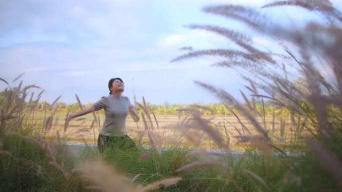 亚洲女性女性手升伸展早晨清新欢快卧室露台背景稻田自然花园和天空