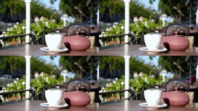 一杯带粉色茶壶的茶。这个女人在法国的一个露台上喝酒。