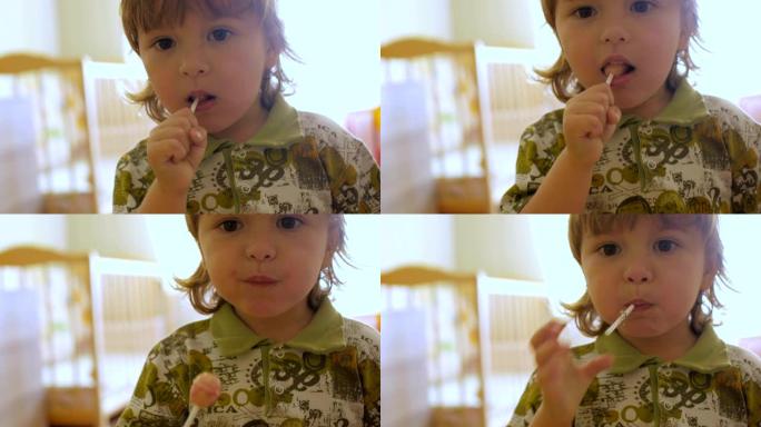 盯着相机看时享受棒棒糖的小男孩。孩子吃糖果，糖果，糖