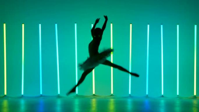 古典芭蕾编舞。年轻的芭蕾舞演员表演舞步，并在明亮的霓虹灯背景下在黑暗的工作室中跳跃。穿着白色短裙的剪
