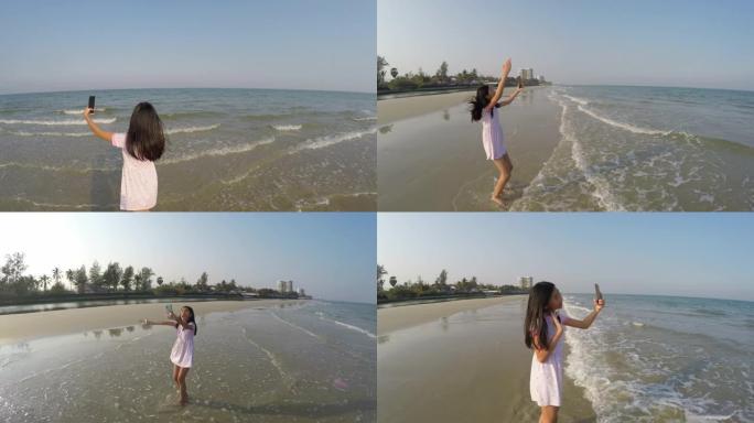 快乐的亚洲女孩自拍自己和视频在阳光明媚的日子里给家人在海滩上打电话，生活方式理念。