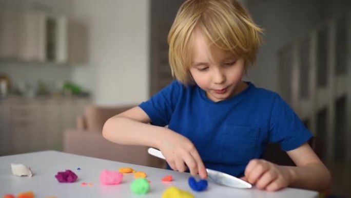 冠状病毒检疫期间，小男孩在家玩面团。橡皮泥制成的儿童成型。创意课程，远程学习，家庭教育，在线幼儿园。