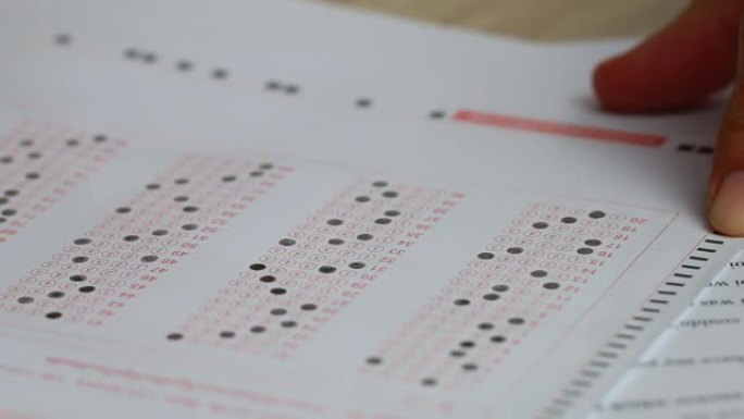 高中大学生在纸质答题纸上拿着铅笔写作考试，在教室里穿着泰国制服做期末考试。教育评估概念