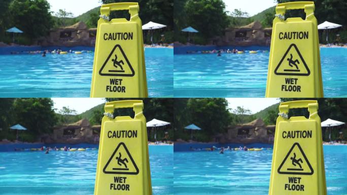游乐园游泳池背景上的黄色湿地板注意标志。游泳池边背景水上公园的注意湿地板标志