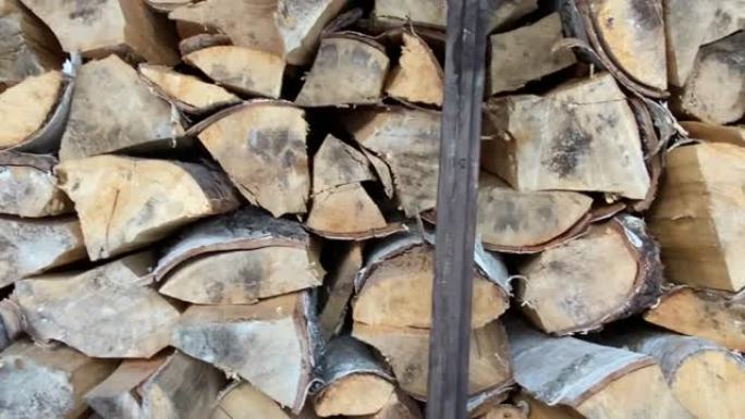 木柴的原木一对一地躺在木棚特写中。冬季的乡村生活。