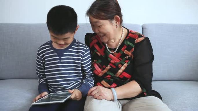 孙子和祖母使用数字平板电脑玩围棋游戏