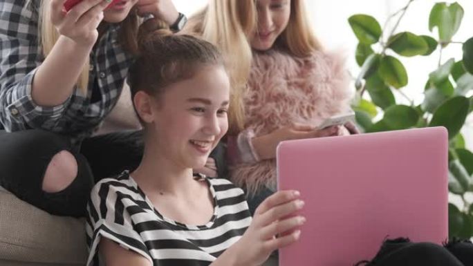 十几岁的女孩在笔记本电脑和手机上浏览社交媒体内容