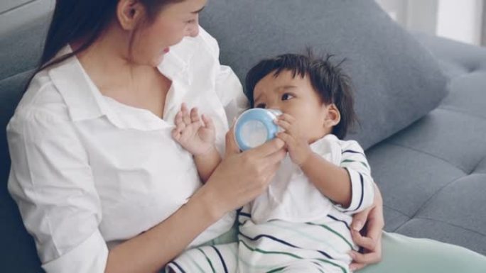 亚洲父母在家客厅给男婴喂奶