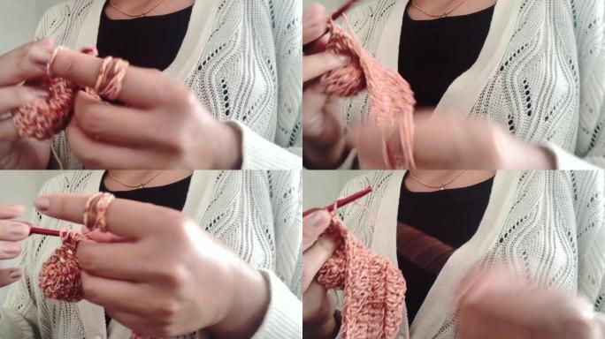 女人的手用钩针钩针编织的特写镜头，并制作手工编织的作品。带有噪声胶片谷物burry bokeh背景。