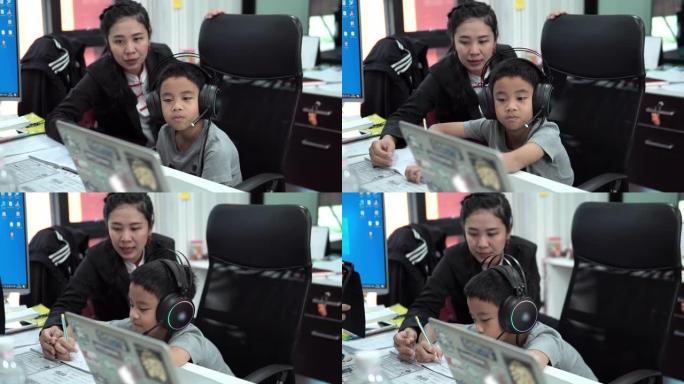 亚洲儿子在家和妈妈一起上在线课。