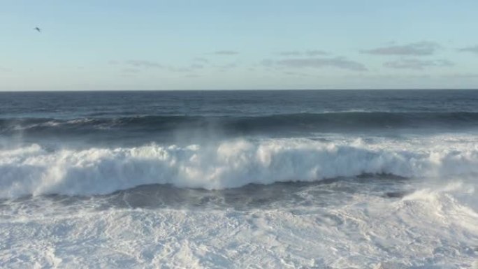 强烈的海浪在开阔的海洋中撞向孤独的灯塔的鸟瞰图