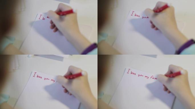 女孩们的手在白纸上写了一个红色的记号笔。