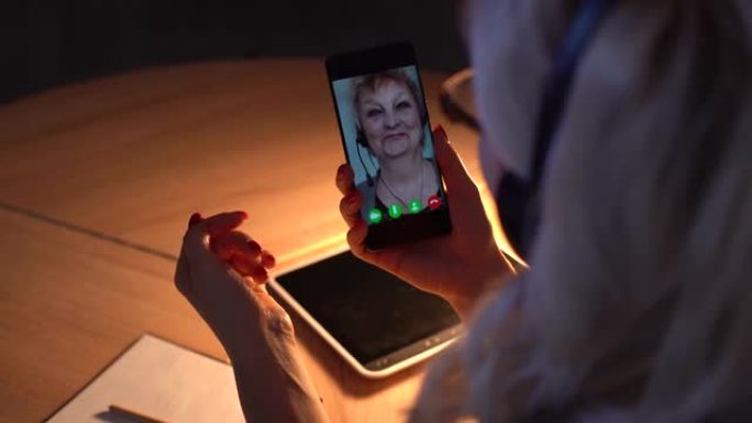 女人使用智能手机聊天进行视频聊天，享受通过手机与家人交谈听力受损的交流
