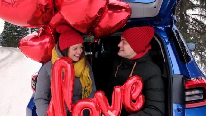 肖像幸福的夫妇的脸看着对方，笑着。红色心形气球和爱字。情人节庆典，浪漫关系，真诚的感情和爱情概念