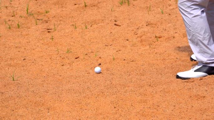 高尔夫球手慢动作在夏季高尔夫球场的沙坑上打挥杆高尔夫球