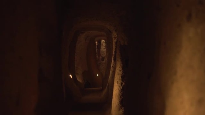 沿着带灯的狭窄半达克手工洞穴隧道运动