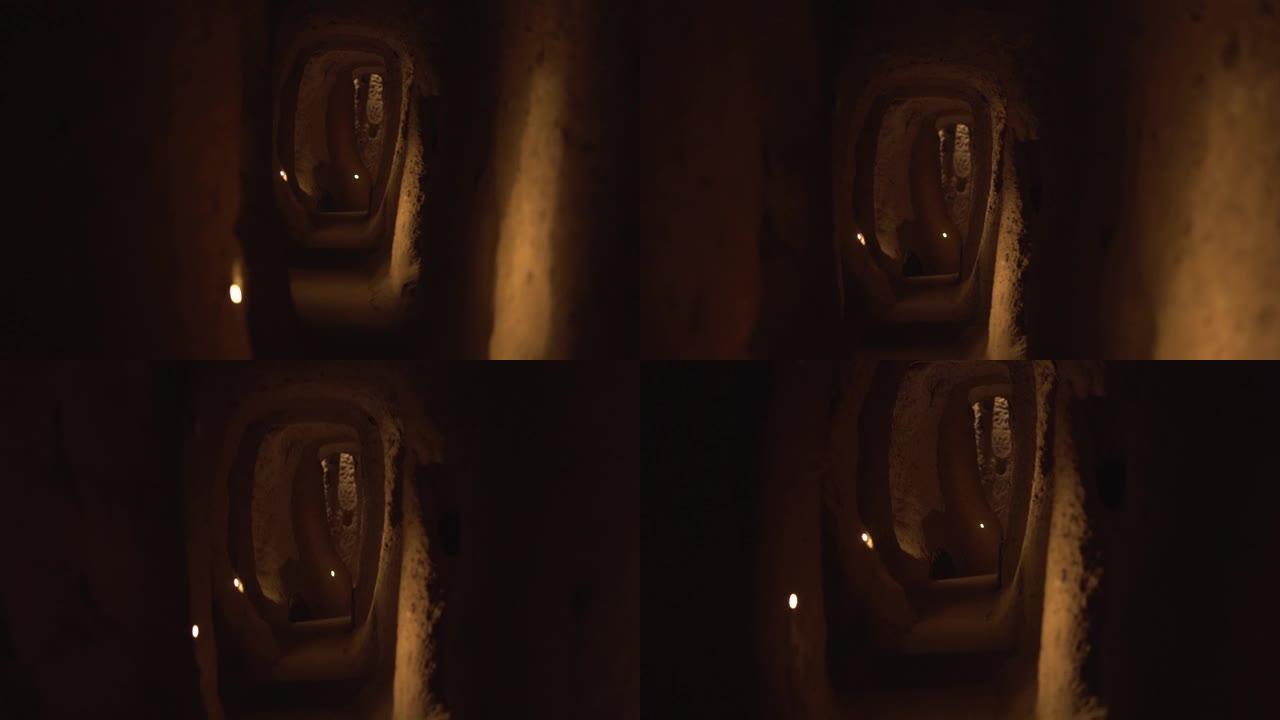 沿着带灯的狭窄半达克手工洞穴隧道运动
