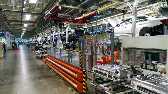 一辆汽车正在工厂组装 工厂车间视图 一个人站在机器前