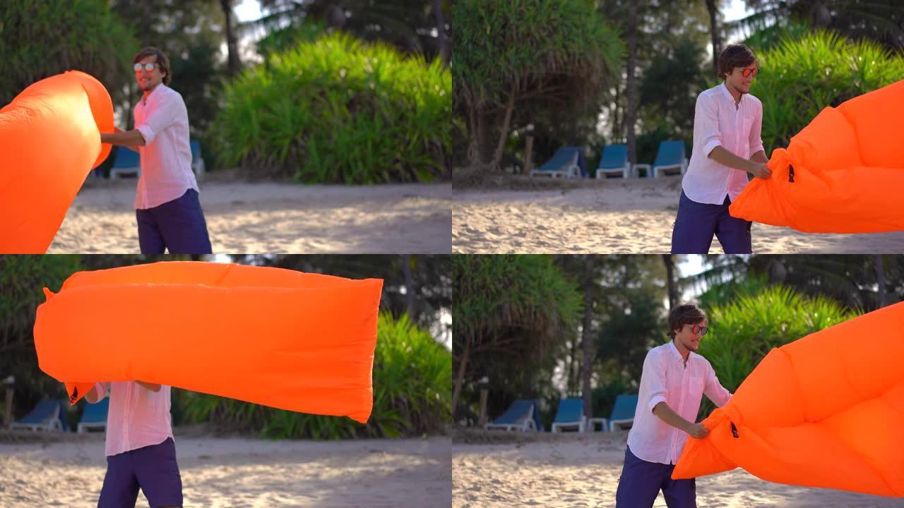 一个年轻人在热带海滩上给一个充气沙发充气。暑假的概念