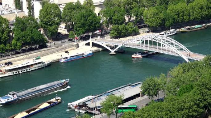 法国巴黎Passerelle Debilly人行天桥下埃菲尔铁塔附近塞纳河上的货船和旅游船的交通