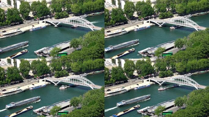 法国巴黎Passerelle Debilly人行天桥下埃菲尔铁塔附近塞纳河上的货船和旅游船的交通