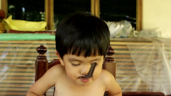 亚洲小男孩在家用勺子吃碗里的甜食