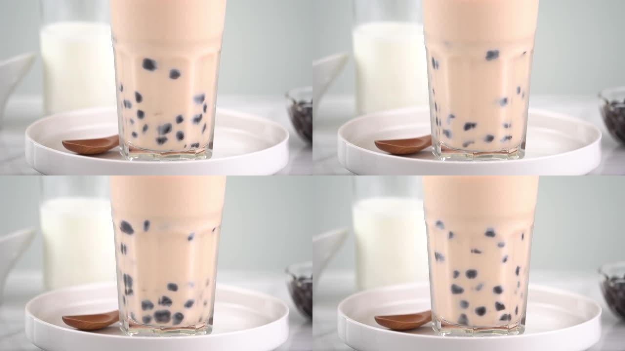 慢动作-在水杯中搅拌木薯珍珠奶茶。
