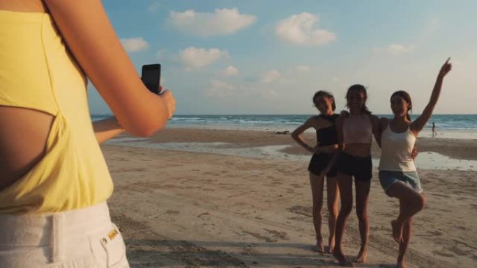 亚洲女团摄影自拍与智能手机一起在海边海滩夏天。青年亚洲快乐情感和周年庆典。4k分辨率和慢动作。