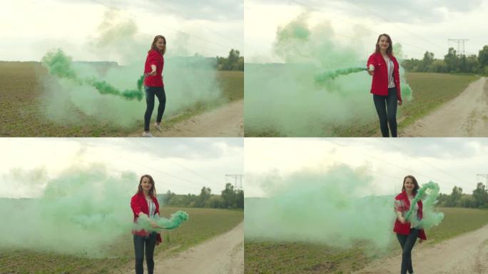 迷人的女人走在田野间的彩色烟雾中