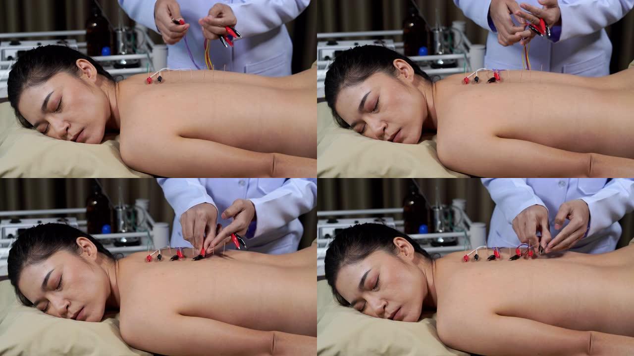 年轻女子背部接受电刺激器针灸治疗