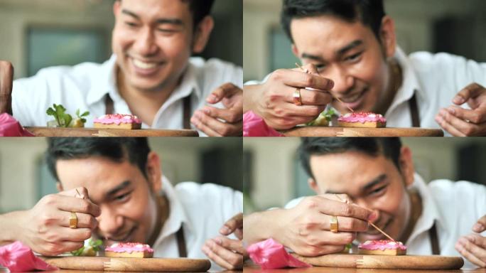 快乐的亚洲男人在家装饰情人节饼干，生活方式理念。