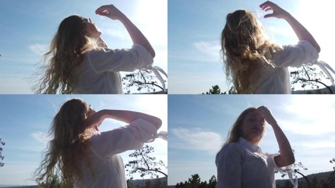 美丽的幸福女孩女人在日落时玩她的金发。4K