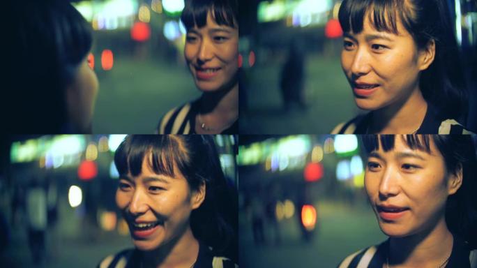 快乐的女性朋友晚上在城市道路上一起闲聊。