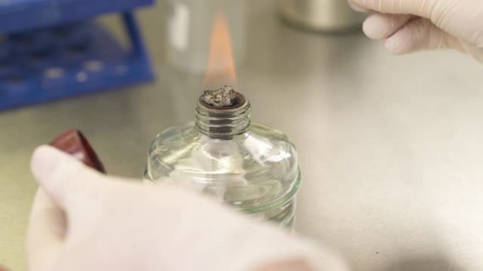 在实验室使用酒精燃烧器的专业技术人员。在实验室工作。特写演示视频