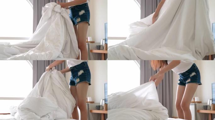 年轻美丽的亚洲女人早上在酒店房间醒来后折叠衣服，然后准备下一次旅行。