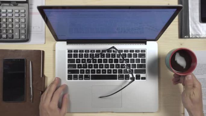 在MacBook上打字的手的俯视图